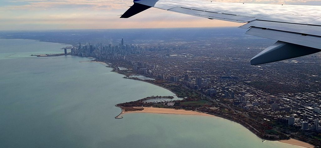 View from an airplane, showing downtown Chicago skyscrapers in the distance.